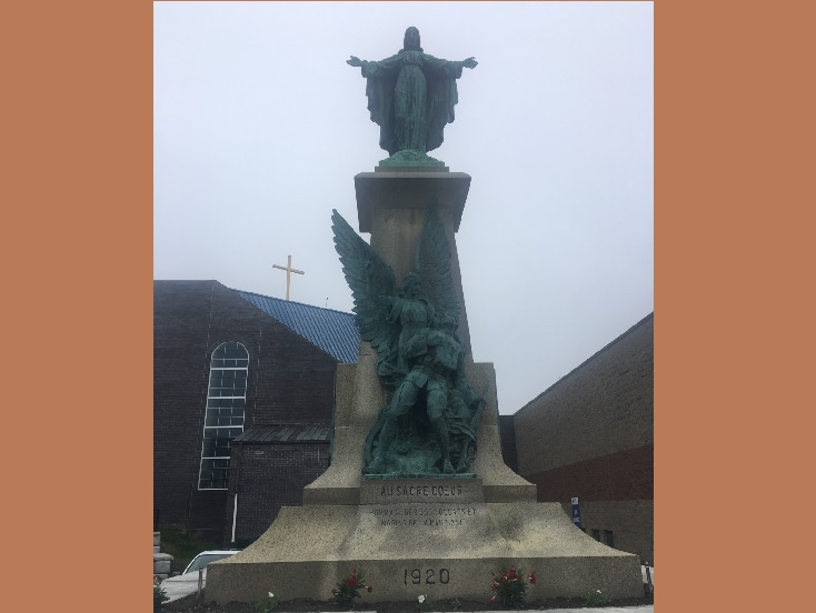 Bronze statue of a religious figure with outstretched arms atop a pedestal with angel carving, in front of a church building, warm sepia and cream tones, reverent and historic mood
